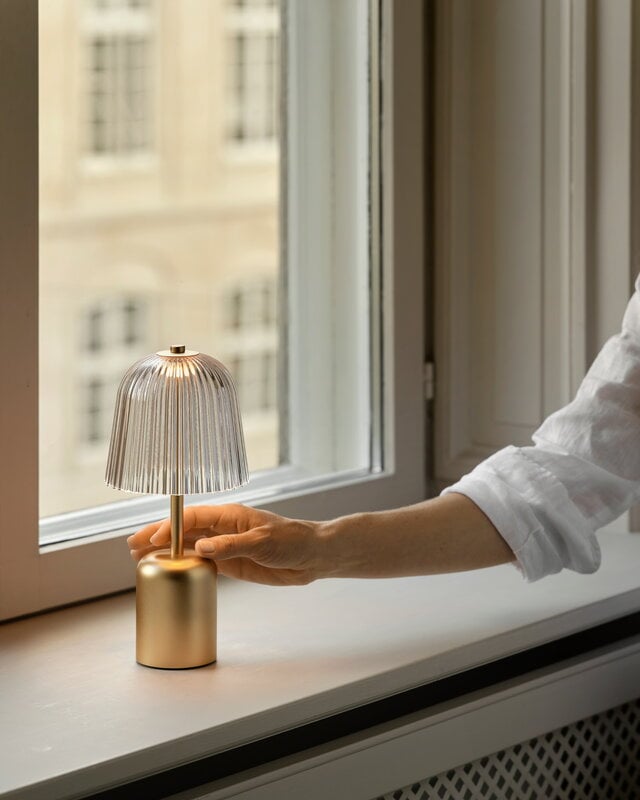 Nuura Asteea portable table lamp, satin brass - ripple clear, decoration image