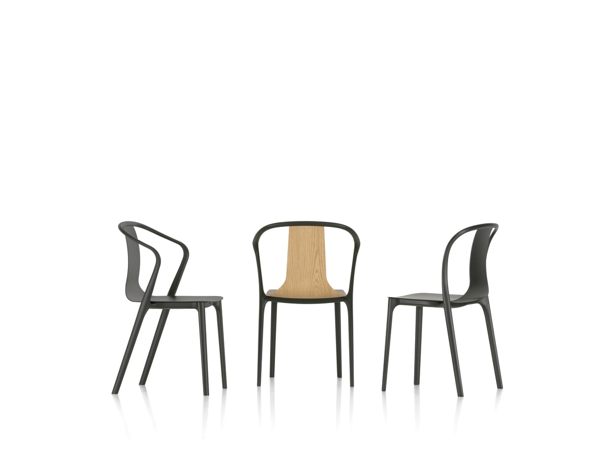 Three black chairs and one light wood chair displayed together.